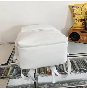 Detailed bottom view of white minimalist waterproof backpack with nylon straps and handle