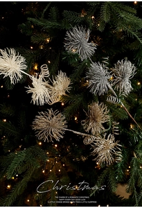 Close-up of sparkling gold, silver and white Christmas flower picks on a lit tree