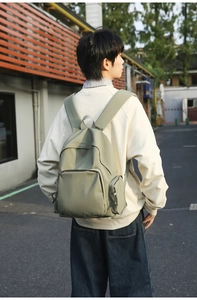 Detailed view of grey-green minimalist waterproof nylon backpack worn outdoors