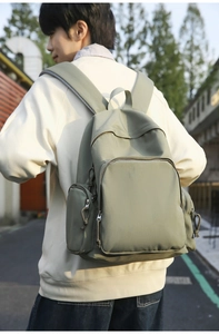 Nylon backpack with multiple pockets and padded straps shown in urban street scene