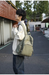 Detailed view of casual olive green nylon backpack showing side pocket and material texture