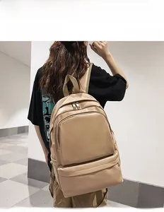 Close-up of matte PU leather backpack in khaki featuring a large front zipper pocket