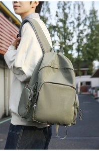 Detail of wide padded shoulder straps on a sage green large capacity nylon backpack