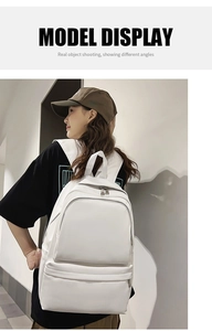 White minimalist backpack for women with large front zipper pocket shown on model