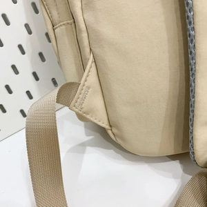 Detail of reinforced triangular stitching and breathable mesh shoulder strap on nylon backpack