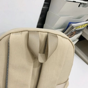 Close-up of reinforced stitching on the nylon backpack handle and shoulder straps