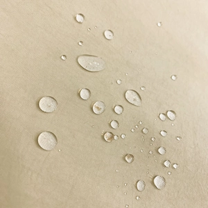 Macro shot of waterproof nylon fabric with water droplets showing water-resistant texture