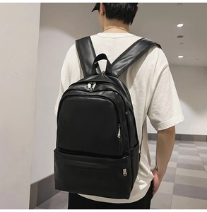 Close-up of a stylish black PU leather backpack worn by a model in a modern hallway
