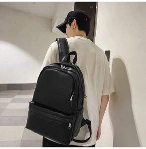 Detailed side view of matte black PU leather backpack showing sleek texture and silver zippers