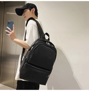 Side view of large black matte leather backpack on person in casual commute setting