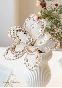 Detail einer weißen Netz-Weihnachtsblume mit goldenem Glitzer und Perlen in der Mitte