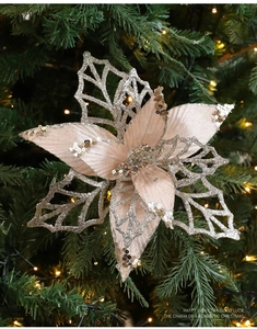 Nahaufnahme einer champagnerrosa Weihnachtsblume mit Glitzer auf einem Tannenbaum