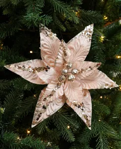 Close-up of pink velvet Christmas flower with gold sequins hanging on a tree