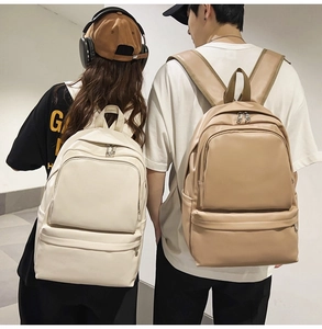 Detailed view of cream and khaki PU leather backpacks with large capacity and silver zippers