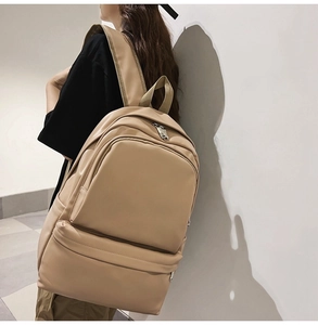 Side view of model wearing a light coffee casual backpack with adjustable straps
