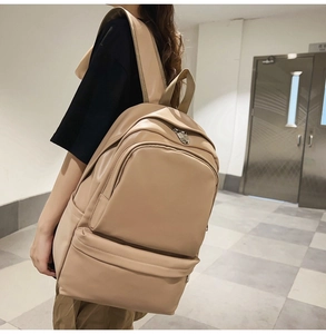 Side view of a beige minimalist leather backpack with large capacity and multi-pocket design