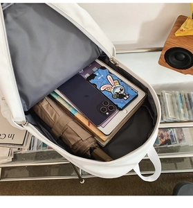 Detail view of white minimalist backpack interior with large capacity storage for tablets