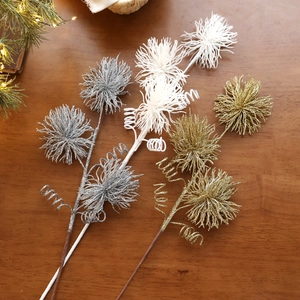 Glittering Christmas decorative stems with firework pom-poms on dark wood background