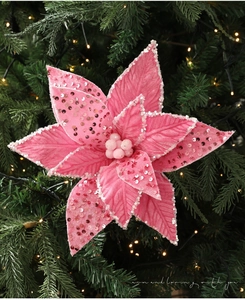 Close-up of pink velvet Christmas flower with sequins and glitter on Xmas tree