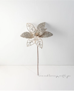 Detailed view of hollowed-out champagne gold Christmas flower with sequins and beadwork