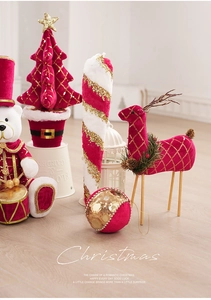 Dettaglio di renne di Natale in peluche rosso e oro e orsetti schiaccianoci da tavolo