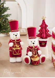 Dettaglio di orsetti natalizi in peluche bianchi e rossi con decorazioni di paillettes d'oro