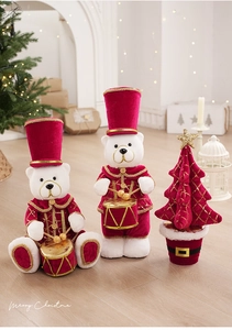 Dettaglio di orsetti schiaccianoci in peluche con ricami dorati e albero di Natale in velluto