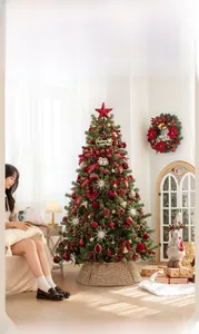 Détail d'un sapin de Noël rouge et or avec lumières chaudes et décorations dans un salon