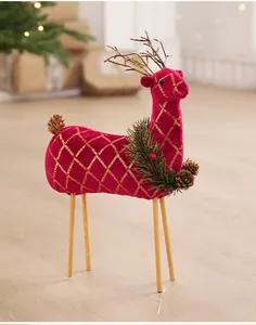 Dettaglio di renna in velluto rosso con paillettes dorate e rami di pino decorativi