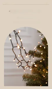 Détail de guirlandes lumineuses LED blanc chaud sur des branches de sapin de Noël réalistes