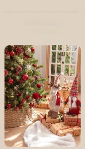 Détail d'un sapin de Noël avec peluche renne, poupée gnome et boîtes cadeaux rouges