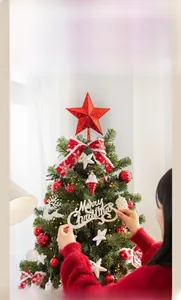 Détail d'un sapin de Noël avec nœuds rouges, ornements et guirlandes lumineuses LED