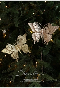 Close-up of glitter champagne butterfly ornaments on a festive Christmas tree