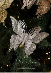 Close-up of glittery hollow butterfly ornaments in gold and silver on Christmas branches
