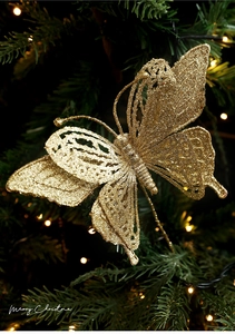 Detailed view of a glittering gold butterfly pick nestled in festive Christmas tree branches