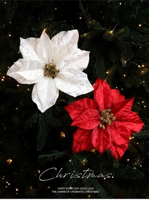 Close-up of red and white velvet Christmas flowers with gold glitter on a festive tree