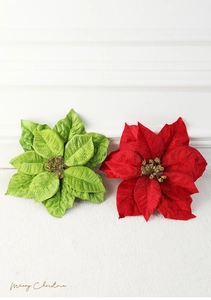 Detail of red and green velvet Christmas poinsettia flowers with gold glitter stamens