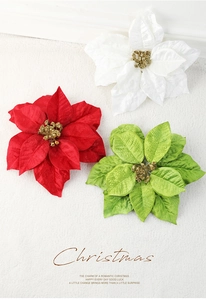 Detailed view of red, white, and green velvet Christmas poinsettias with gold glitter