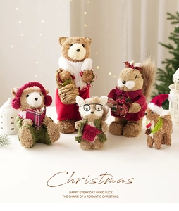 Close-up of five handmade straw Christmas animal figurines in festive knitwear