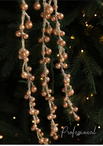 Dettaglio di un ramo decorativo con perle dorate su un albero di Natale luminoso