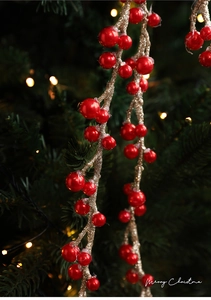 Dettaglio di bacche di Natale rosse con glitter dorati su uno sfondo festivo