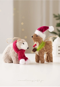 Detail of straw woven Christmas bear and reindeer figurines with red scarves and pine cones