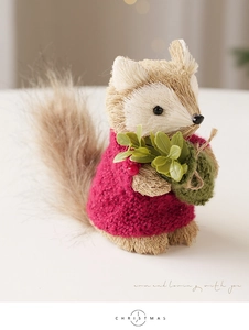 Close-up of squirrel Christmas decoration with straw texture and red knit sweater