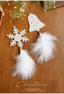 Detail of Christmas snowflake and bell ornaments with white pearls and soft feather trim