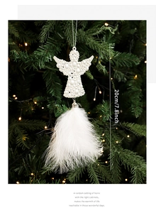 Detail of white pearl angel ornament with fluffy feathers on a Christmas tree branch