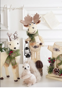 Figurines de renne de Noël avec pommes de pin et lanterne sur un décor boisé