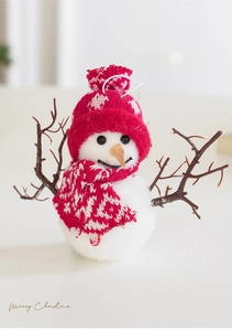 Détail du bonhomme de neige de Noël avec bonnet rouge, écharpe et bras en bois