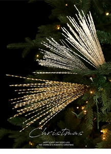 Close-up of glittery spiral Christmas picks in gold, silver, and white on a tree