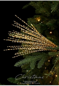 Close-up of golden spiral glitter picks nestled in green Christmas tree branches