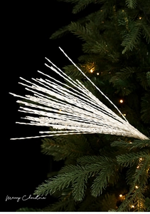 Close-up of white glittery wave branches with sparkles on a green Christmas tree detail